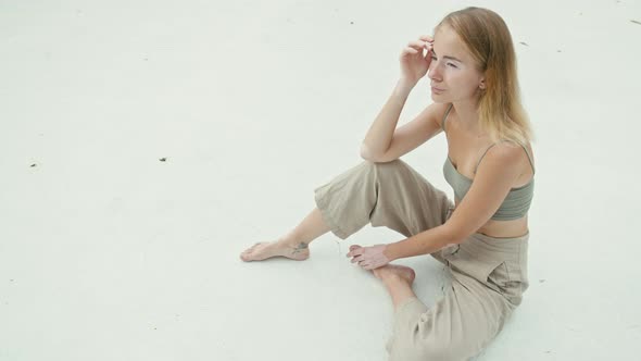 Pretty Young Woman with Vitiligo Pigmentation Sitting on the White Floor Looking at the Camera