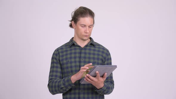 Happy Hipster Man Thinking While Using Digital Tablet