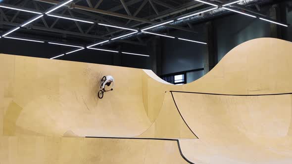 BMX Sports  Young Man Riding on the Springboards on the Indoors Training Ground