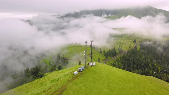 View from drone to GSM tower and radio communications in mountains in clouds.