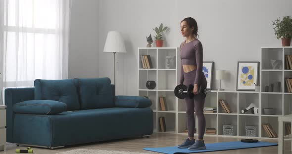 Workout of Woman with Dumbbells in Hands Training in Living Room at Weekends Wellness Power Training