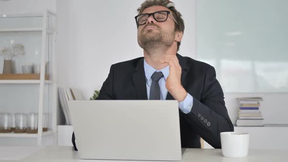 Businessman with Neck Pain Working on Laptop