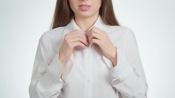 Sexy woman undresses unbuttoning the buttons on a white business shirt.