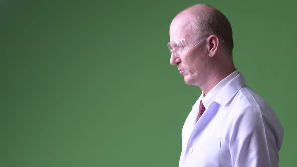 Profile View of Mature Bald Man Doctor Wearing Protective Glasses