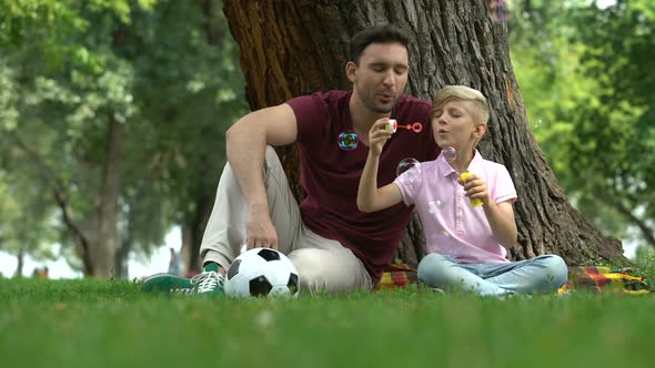 Carefree Boy Blowing Bubbles, Father Playing With Son in Park, Happy Weekend