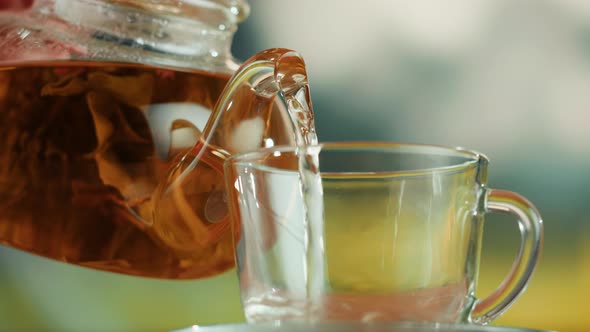 Pouring Fresh Tea in Glass Cup Closeup