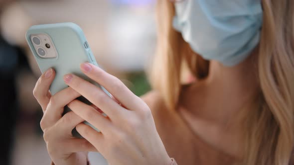 Unrecognizable Young Woman in Medical Face Mask Typing Message on Smartphone Close Up Unknown Girl