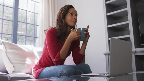 Mixed race woman enjoying drinking tea. Social distancing and self isolation in quarantine