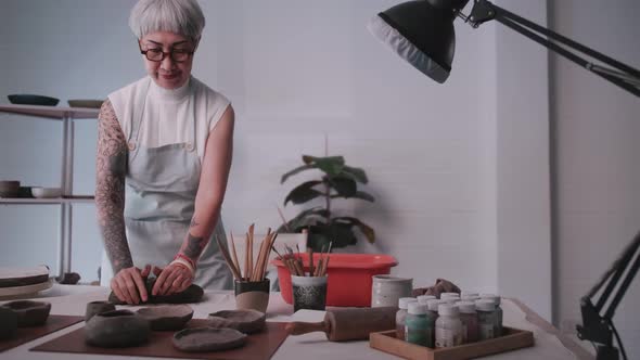 Asian elderly woman enjoying pottery work at home.