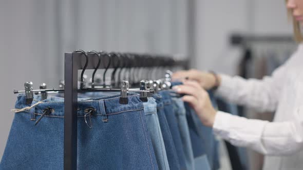 Unrecognizable Slim Young Woman Choosing Jeans Clothes in Shop on Black Friday Sales