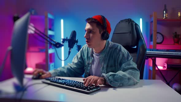 Young Hipster Man Playing Online Computer Video Game Colorful Lighting Broadcast Streaming Live Home