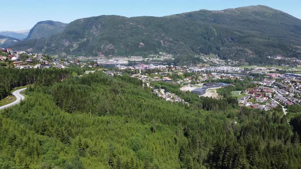 Sideways moving aerial of Førde and Førdefjorden sea from a distance - Watching road and forest with