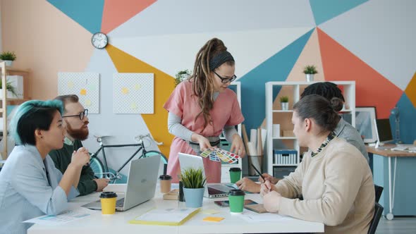 Multi-ethnic Team of Creative Designers Talking Looking at Color Palettes in Office