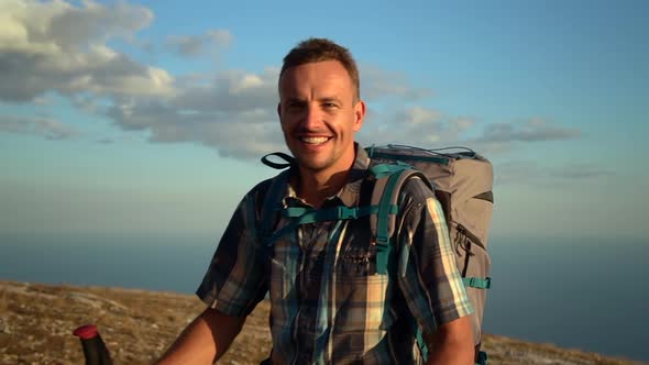 Portrait of Man Hiker As He Walk with Trekking Poles Outdoors on Setting Sun