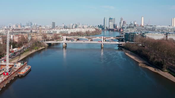Descending drone shot over London river thames at battersea power station Chelsea Bridge
