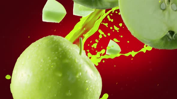 Green Apple with Slices Falling on Deep Red Background