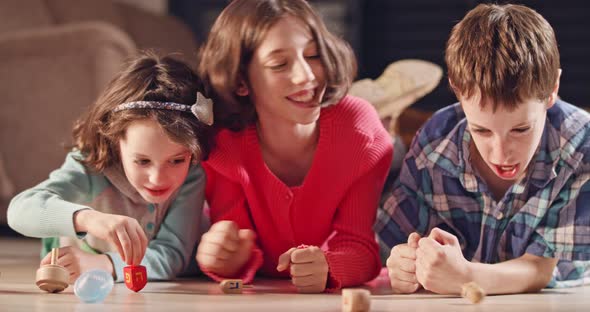 Kids playing with dreidels during Hanukka at home