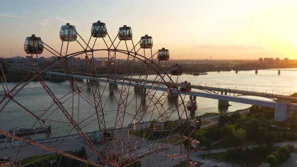 Drone View Colorful Ferris Wheel in Amusement Park on River and City Landscape