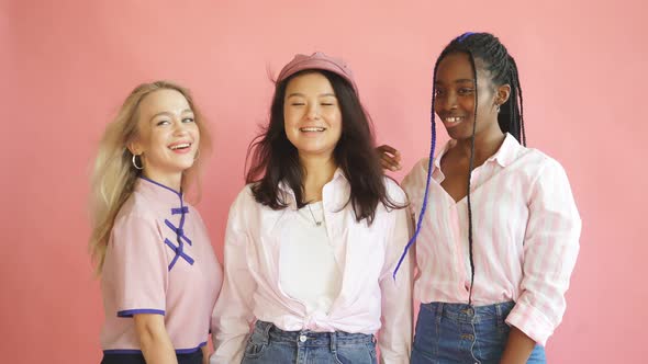 Mixed Race Cheerful Women Friends Posing with Smile and Have a Fun on Pink Background.