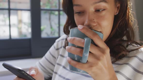 Mixed race woman enjoying drinking tea. Social distancing and self isolation in quarantine