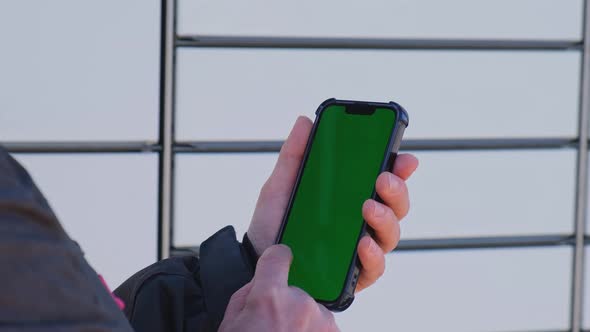 Unrecognizable Woman Holding Mobile Phone with Chroma Key Using App Next to Shopping Locker