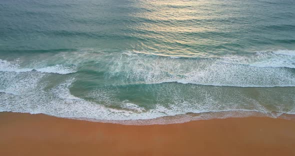 Aerial view Top view of seawater wave in nature on sandy beach. In sunset time. Summer beach sea