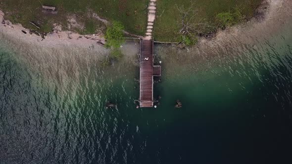 Man walking on the platform molo on the blue water lake