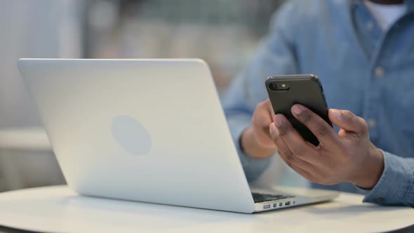 Man Working on Smartphone and Laptop Close Up