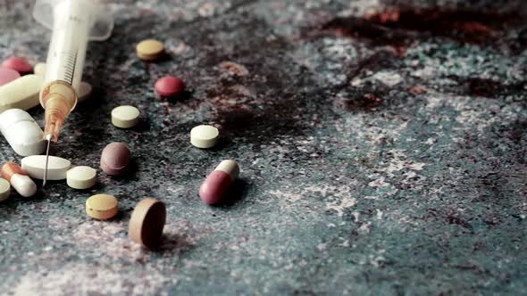 Syringe and Pills on Dark Background Close Up