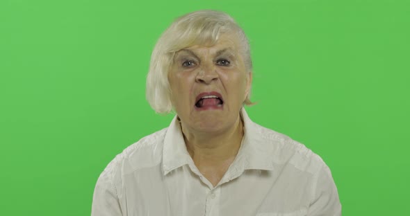 An Elderly Woman Shows Tongue. Old Pretty Happy Grandmother. Chroma Key