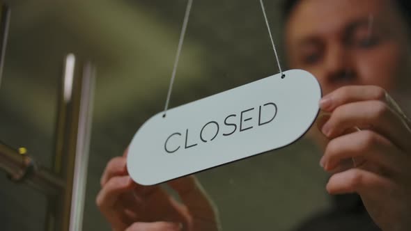 Closeup of Young Barber Turning Door Closed Nameplate to Open