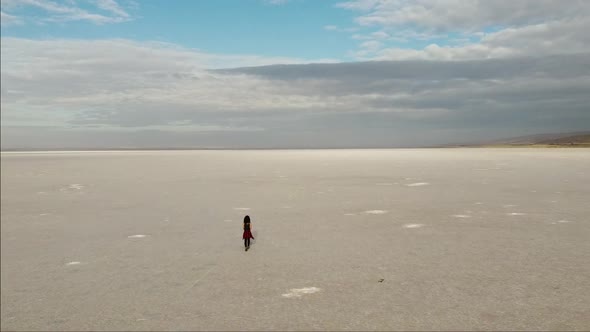 Flying over a girl walking on the pink salt lake, the largest dry lake in Turkey and one of the larg