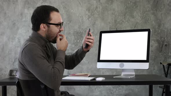 Man Checking His Teeth in the Office Near Computer Screen. White Display.