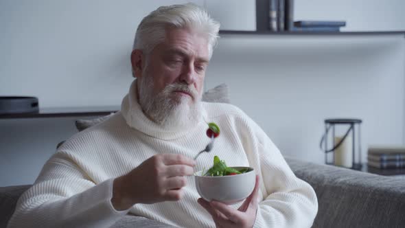 Elderly Man Feel Happy Enjoy Eating Diet Food Fresh Salad on Sofa