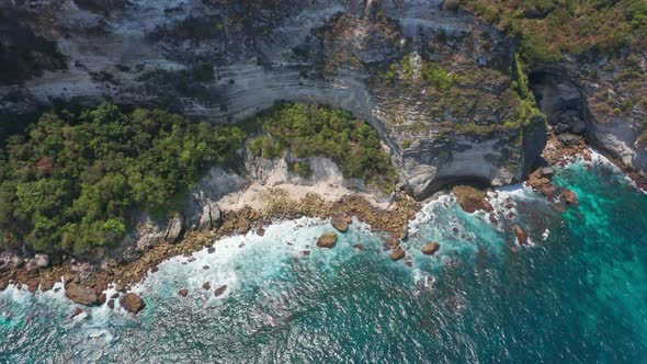 Aerial Shot of Waves Hitting Against Rocky Depths in a Beach in Bali, Indonesia