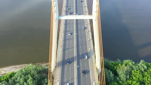 Aerial view of car traffic on modern bridge over river in city in summer day