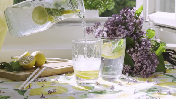 Pouring Soda Water with Lemon Slices Into a Glass