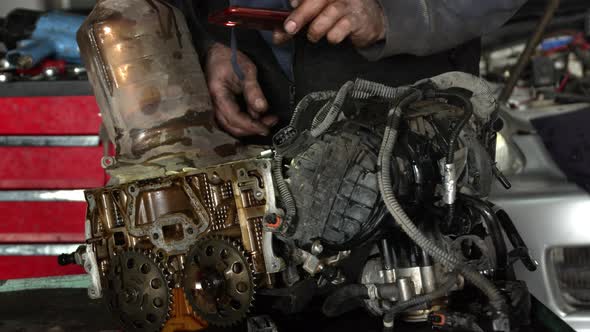 Workshop Master Checks Cylinder Head Of A Dismantled Vehicle Engine Through His Eyes