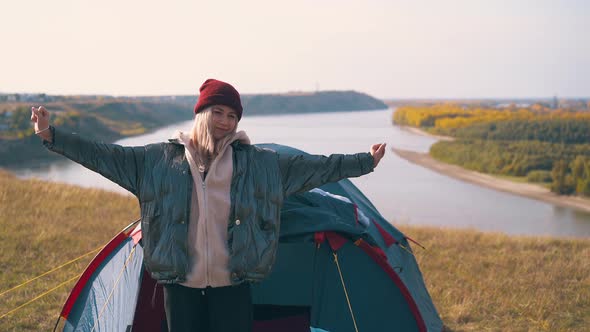 Girl Hiker Goes Out of Tent Stretching Against Sky and River