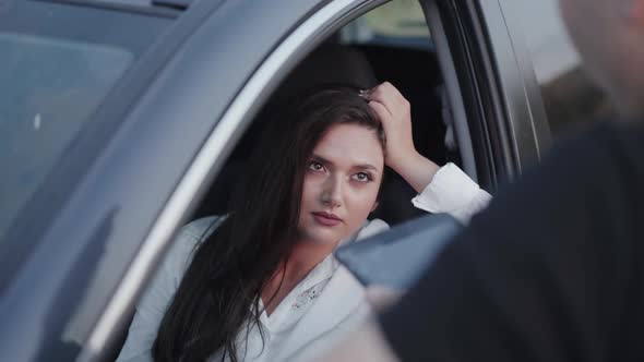 Longhaired Brunette in Car Talking with Officer with Gadgets and Rejoicing