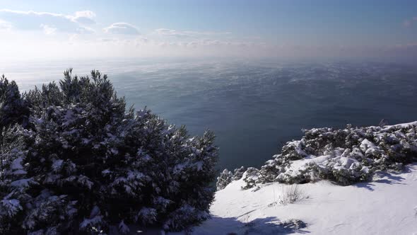 Snow Covered Rocky Cliffs Over Sea