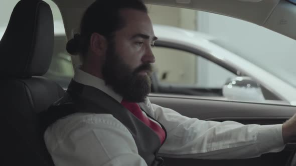 Portrait Attractive Successful Bearded Businessman Sitting in the Vehicle and Inspects Newly