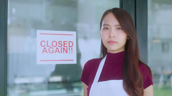 Asian female cafe business owner stressful hand handing shop close againd