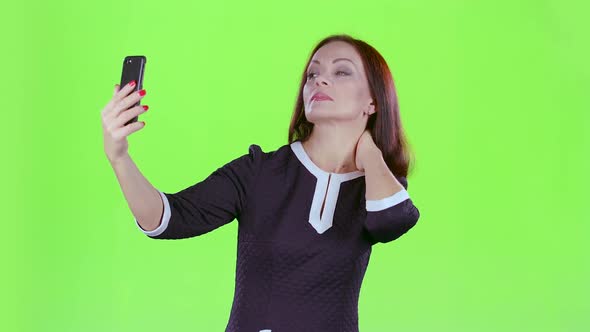 Woman Makes Selfie on Her Phone. Green Screen