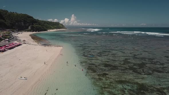 Aerial View of Tropical Beach with Azure Blue Water and Foaming Ocean Waves