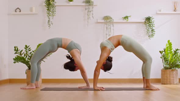 Wellness Couple Asian young woman on yoga mat doing breathing exercise yoga bridge pose stretching m