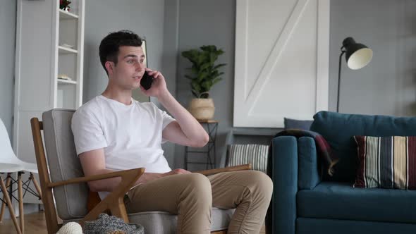 Man Talking on Phone While Sitting on Couch