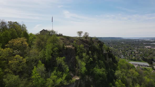Craggy mountain side with small shelter overlooking midwest Mississippi River valley city.