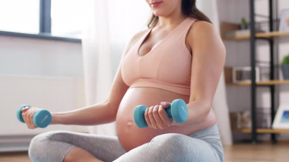 Pregnant Woman with Dumbbells Doing Sports at Home