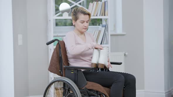 Young Female Paralyzed Figure Skater Putting Away Ice Skates and Rolling Wheelchair Leaving